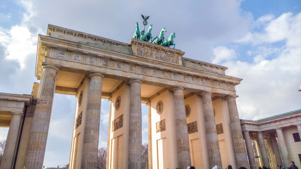 Brandenburg Gate Berlin neoclassical monument under dramatic thick clouds vibrant daylight wallpaper