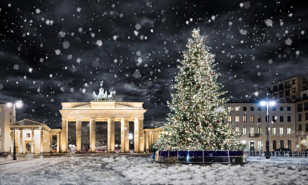 Brandenburg Gate Christmas tree illuminated with festive lights and snowfall at night in Berlin Wallpaper