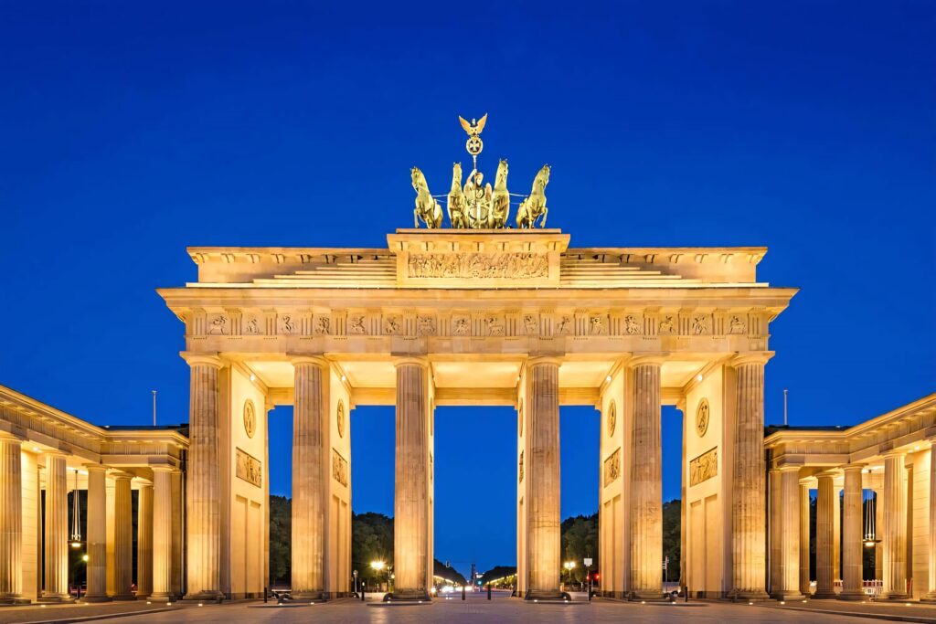 Brandenburg Gate at night with golden lights under dark blue sky neoclassical architecture wallpaper