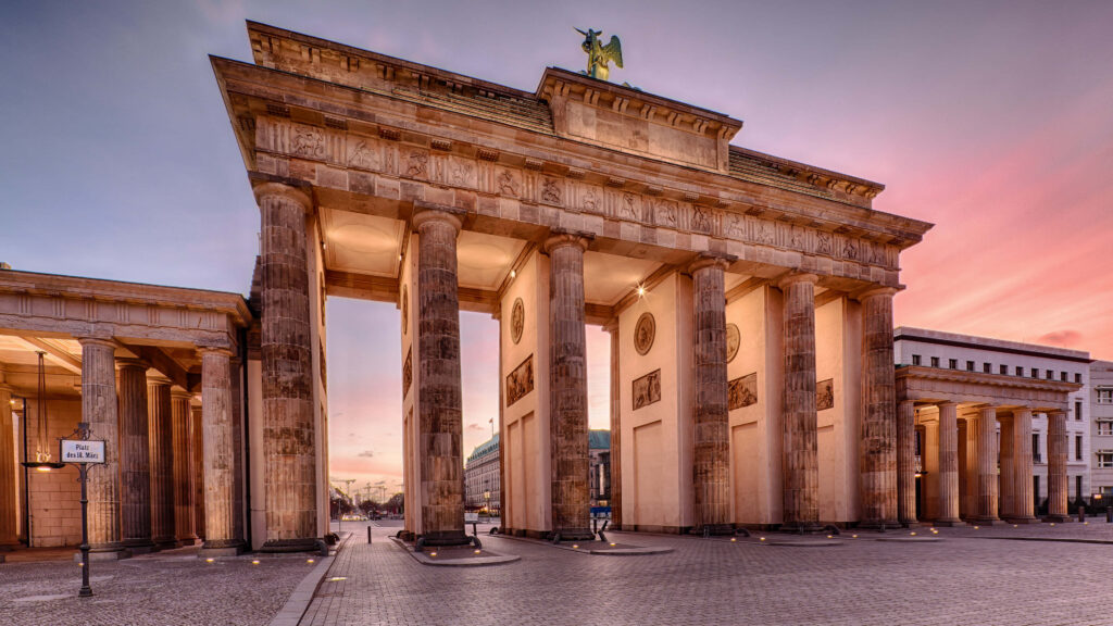 Brandenburg Gate Berlin illuminated at twilight with pink and blue sky vibrant neoclassical architecture Wallpaper
