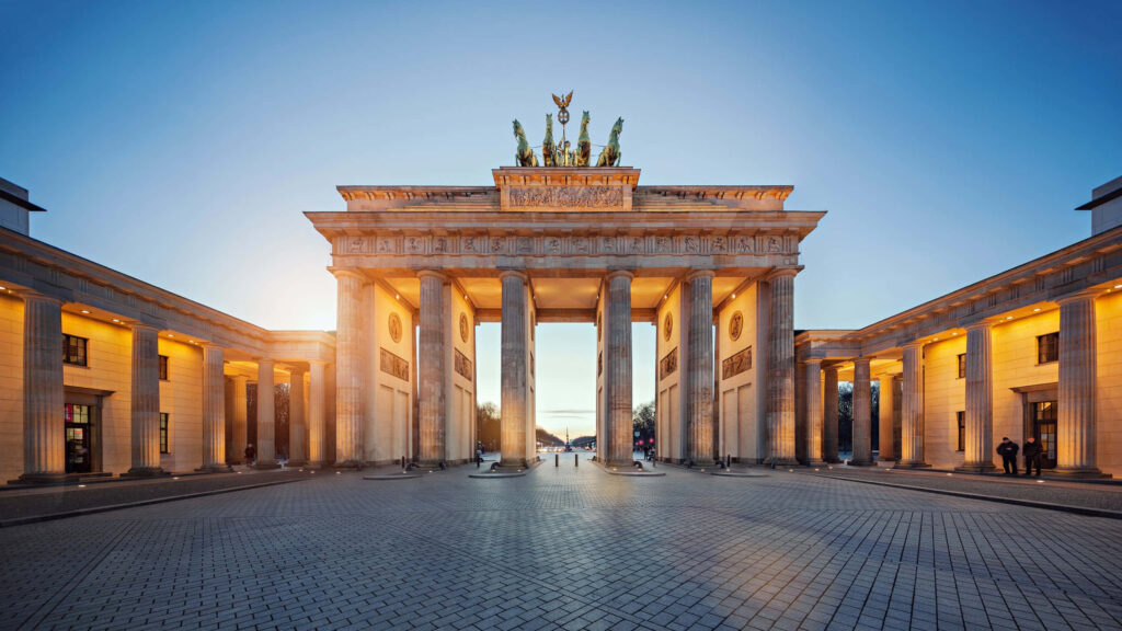 Brandenburg Gate Quadriga Berlin illuminated at sunrise with neoclassical columns and clear sky Wallpaper