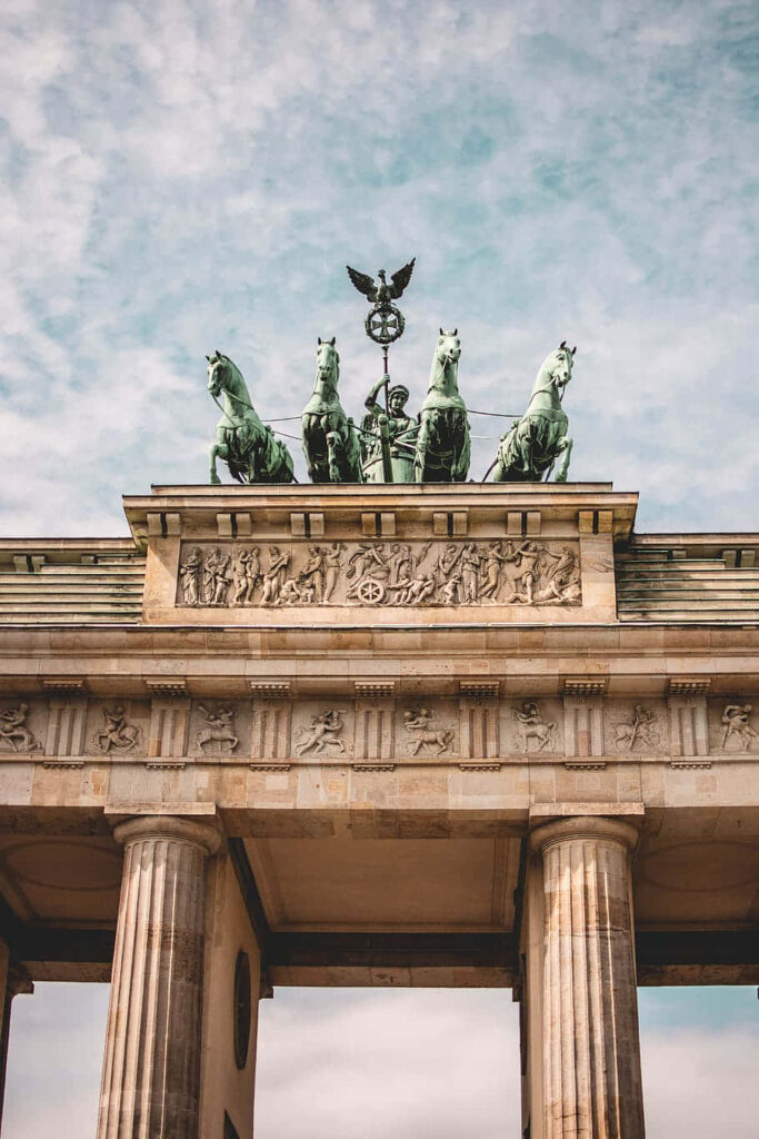 Brandenburg Gate Quadriga with detailed columns and four-horse chariot under cloudy sky wallpaper