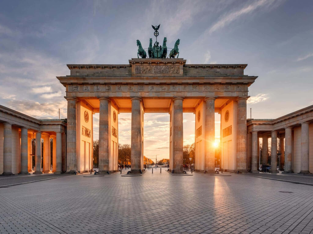 Brandenburg Gate Berlin sunset vibrant golden light majestic columns dramatic sky wallpaper