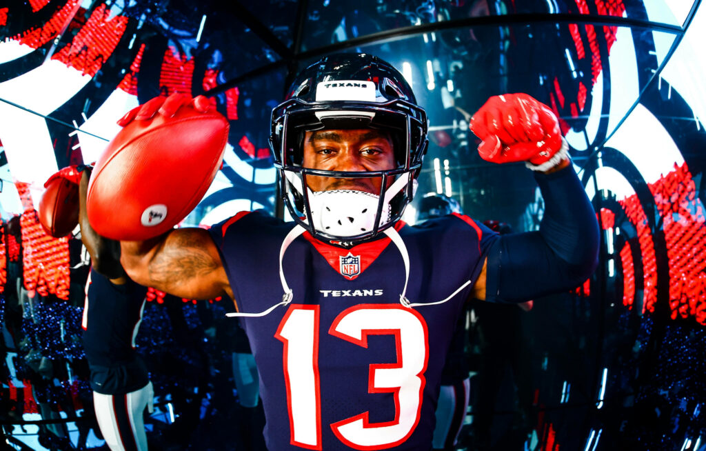 Brandin Cooks Houston Texans flexing muscles holding football vibrant blue red sports wallpaper background
