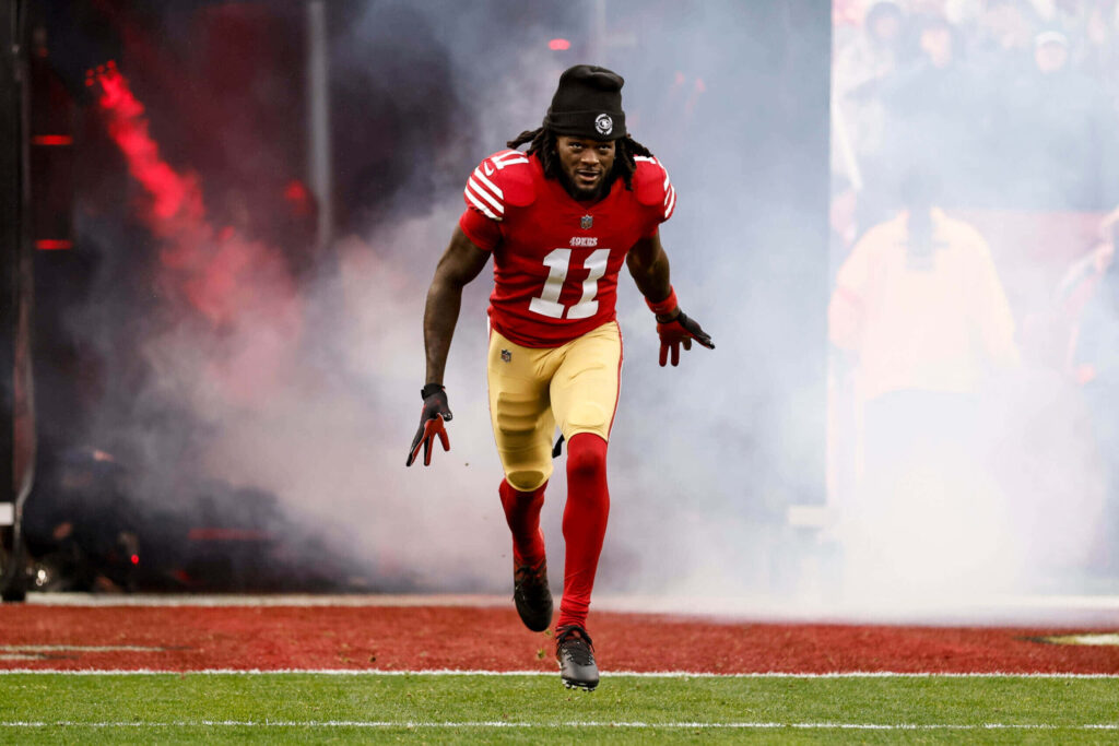 Brandon Aiyuk sprinting onto field 49ers uniform dramatic smoke stadium lights wallpaper