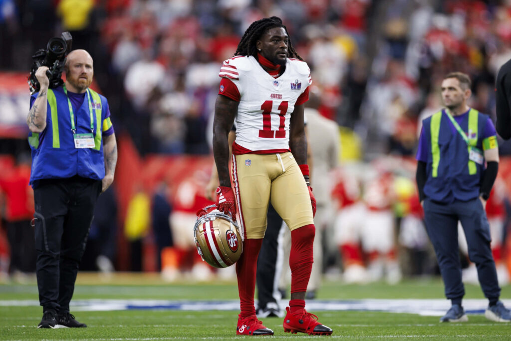 Brandon Aiyuk in San Francisco 49ers uniform on field vibrant red gold NFL football action wallpaper