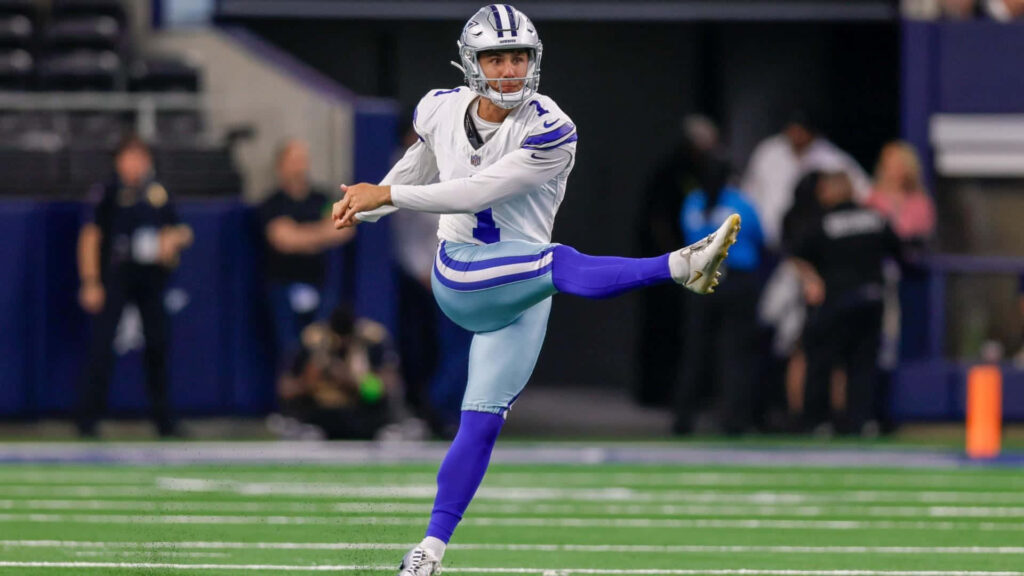 Brandon Aubrey Dallas Cowboys kicker mid-kick vibrant NFL football action stadium background Wallpaper