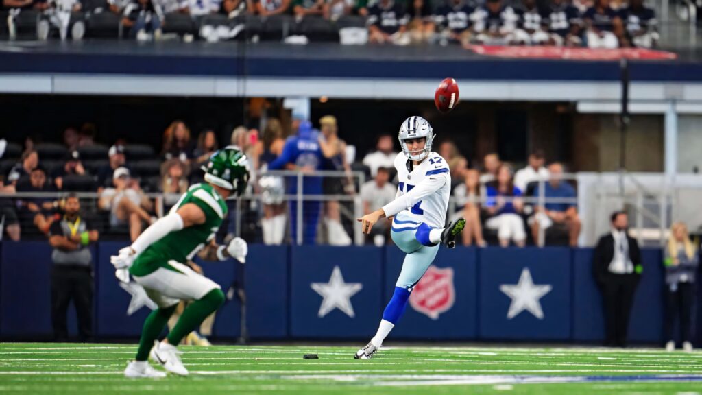 Brandon Aubrey Dallas Cowboys kicker mid kick NFL game vibrant stadium lighting wallpaper background