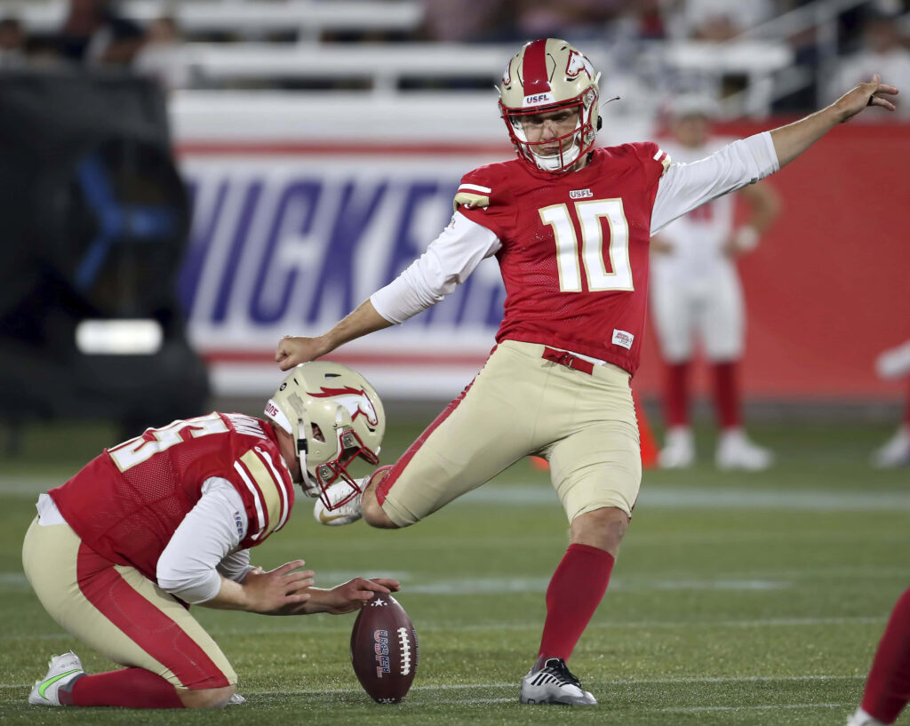 Brandon Aubrey football kicker in red gold uniform kicking field goal high resolution wallpaper