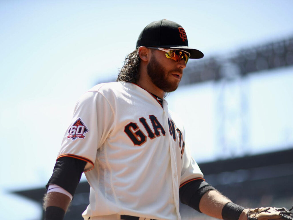 Brandon Crawford in white Giants uniform ready to swing bat at vibrant MLB stadium game day Wallpaper