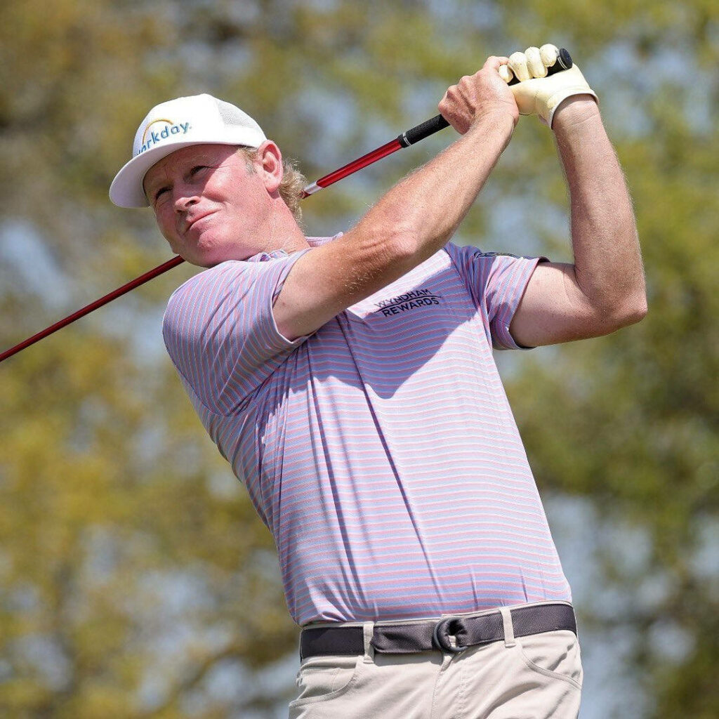 Brandt Snedeker focused golf swing wallpaper with purple polo and white cap outdoors background