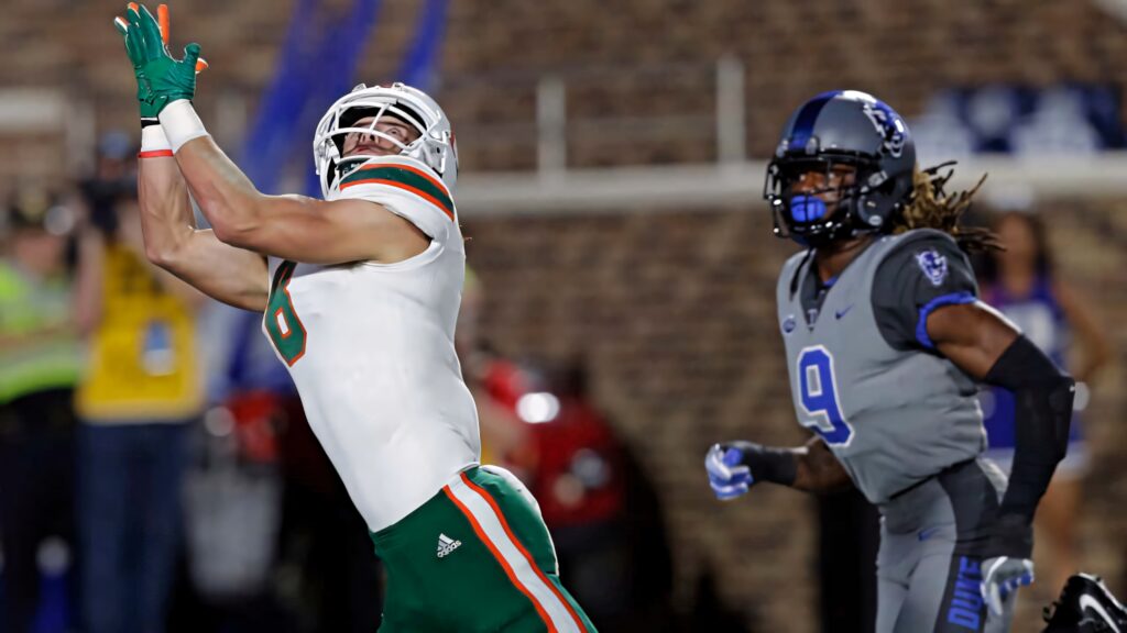 Braxton Berrios catching football in action intense focus stadium vibrant uniforms sports wallpaper