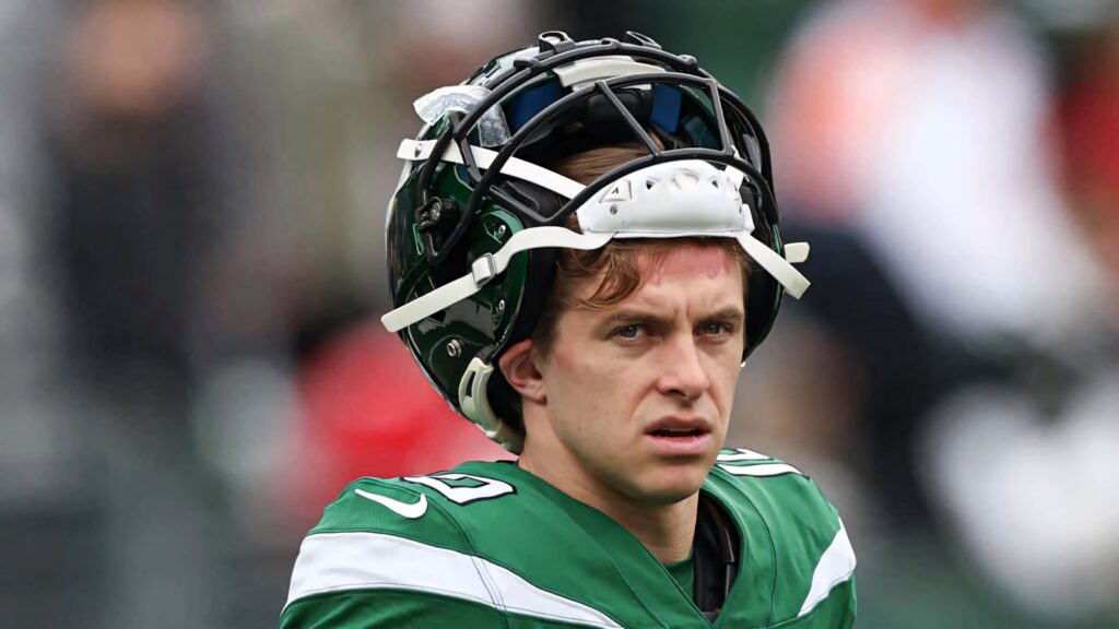 Braxton Berrios focused NFL player in green uniform with raised helmet football wallpaper background