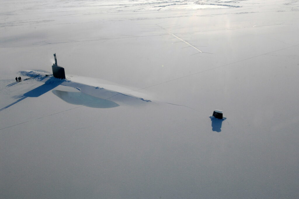 Silent Steel: Illuminating the Depths - US Navy Submarine Breaking The Ice Wallpaper