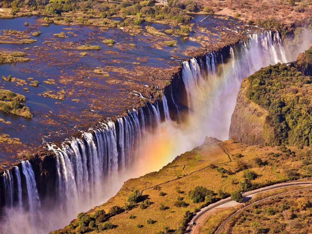 Breathtaking Aerial Waterfall Wallpaper with Rainbow and Lush Greens