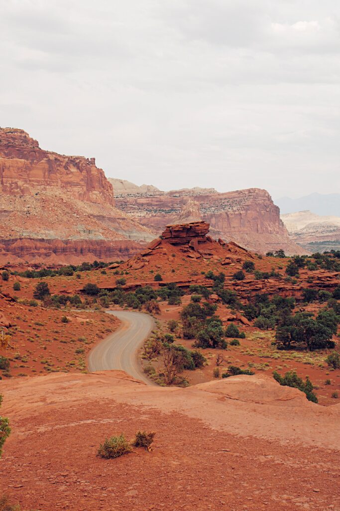 Breathtaking American Southwest canyon with red rocks winding road and mountainous landscape Wallpaper