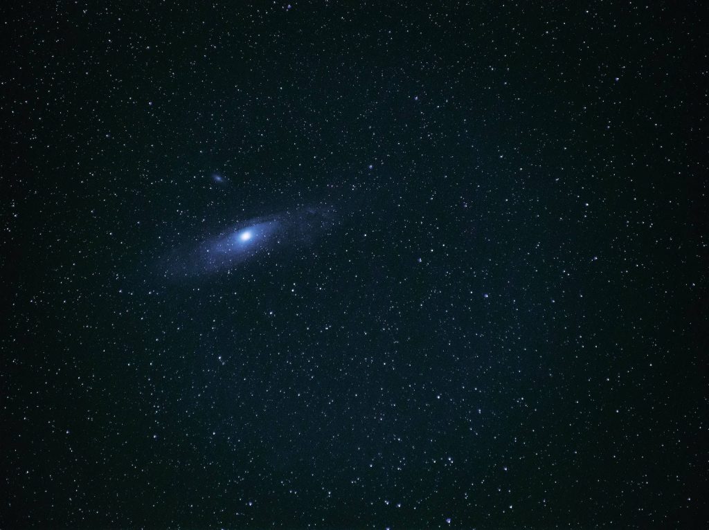 Astrophotography of Andromeda Galaxy glowing in night sky with scattered stars HD wallpaper background