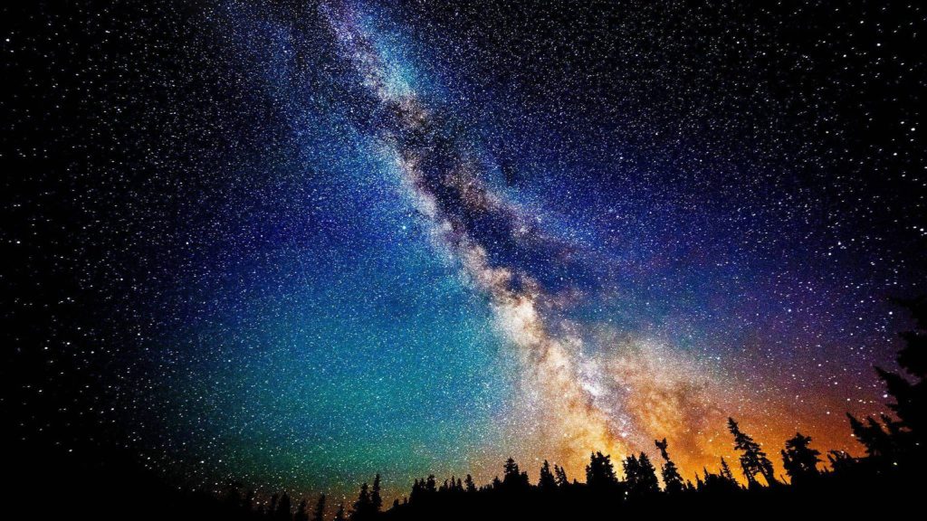 High-resolution Black Galaxy Milky Way astrophotography over dark forest silhouette wallpaper