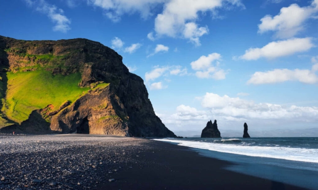 Breathtaking Black Sand Beach: Dramatic Cliffs & Clear Blue Sky Wallpaper