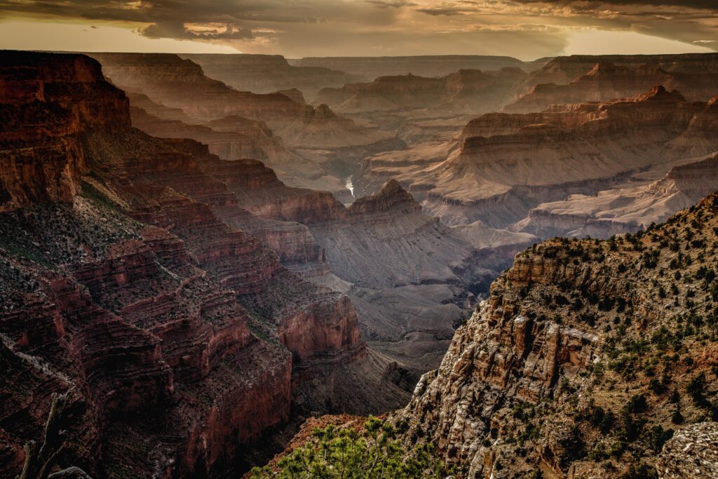 Breathtaking canyon landscape with rugged rock formations and towering sunlit mountains background Wallpaper