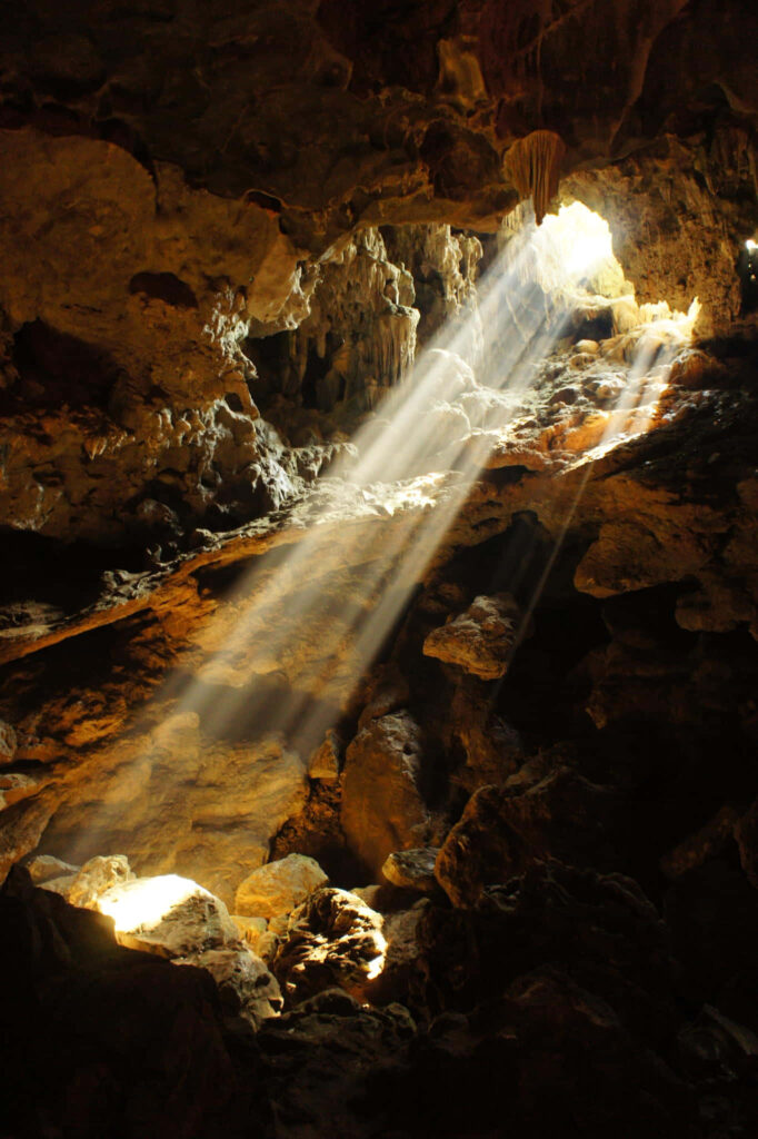 Breathtaking Cave Interior: Sunlit Rock Formations & Golden Hues Wallpaper