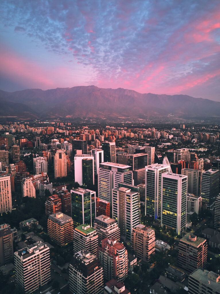 Breathtaking Cityscape Wallpaper: Sunset with Mountains & Modern Towers