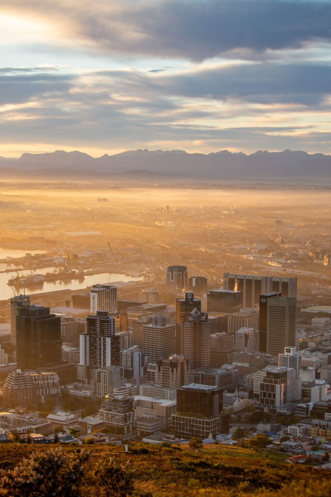 Stunning Aerial Cityscape Wallpaper with Majestic Mountain Backdrop