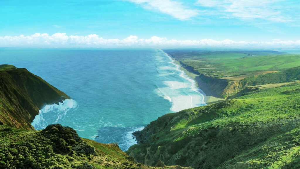 Breathtaking Coastal Cliffs: Lush Greenery & Clear Blue Ocean Background Wallpaper