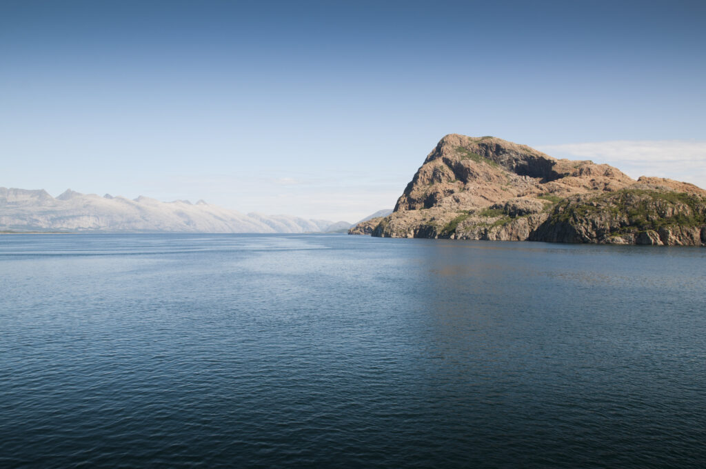 Breathtaking coastal landscape with blue waters rugged mountains and dramatic cliffs wallpaper background
