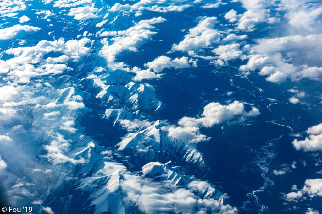 Breathtaking Aerial HD Wallpaper: Snow-Capped Mountains & Clouds