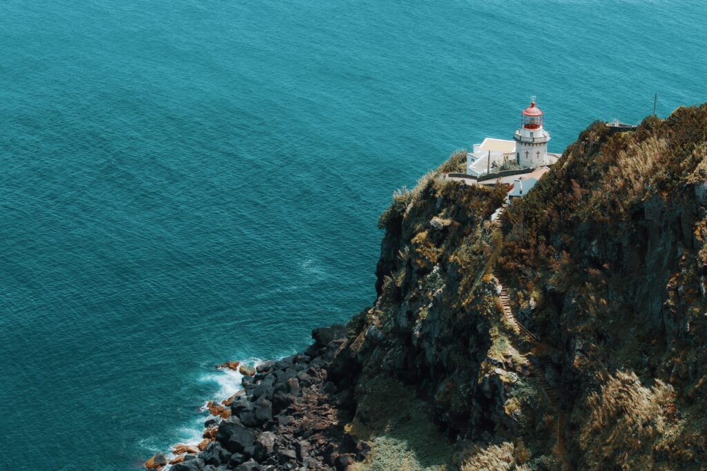 Breathtaking Lighthouse Wallpaper: Rugged Cliffs & Blue Sea Beauty