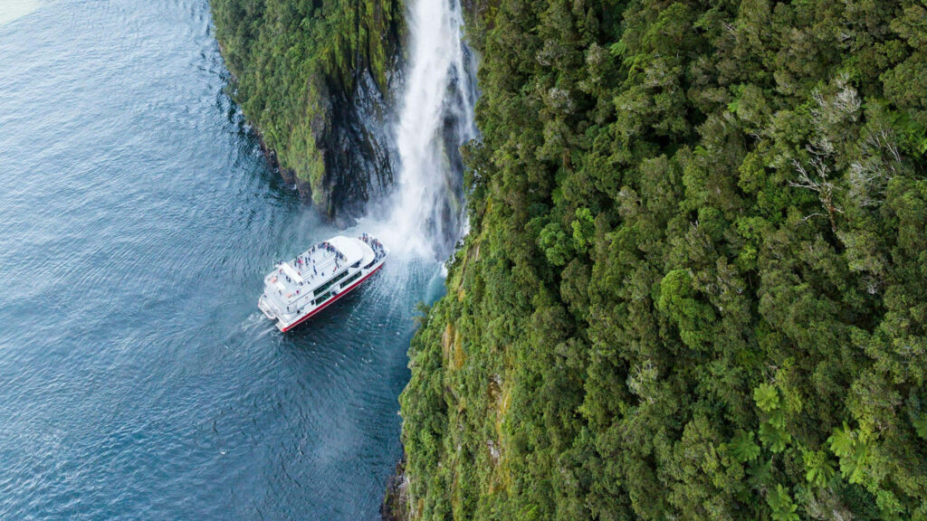 Breathtaking Milford Sound: Lush Mossy Cliff & Cascading Waterfall Wallpaper
