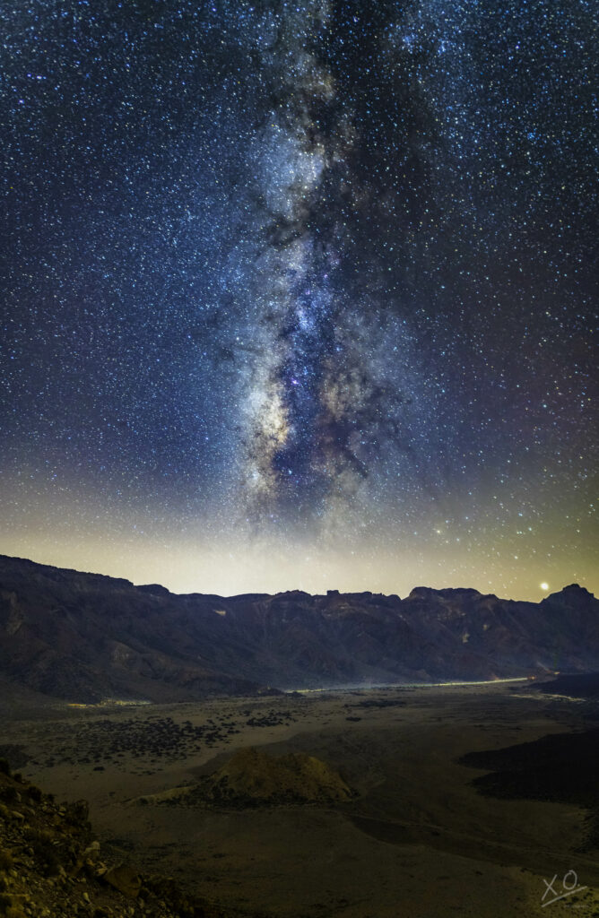 Milky Way galaxy over rugged mountains starry night sky vibrant cosmic colors wallpaper background