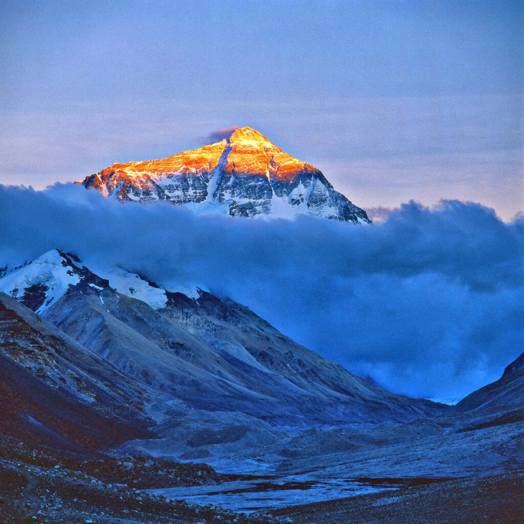 Golden Sunlit Mount Everest: Majestic Cloudscape Wallpaper Background