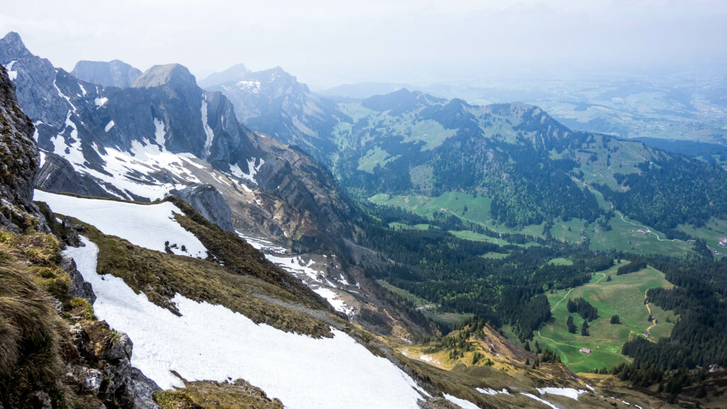 Breathtaking mountain landscape with melting snow rugged rocks green valleys and misty peaks wallpaper