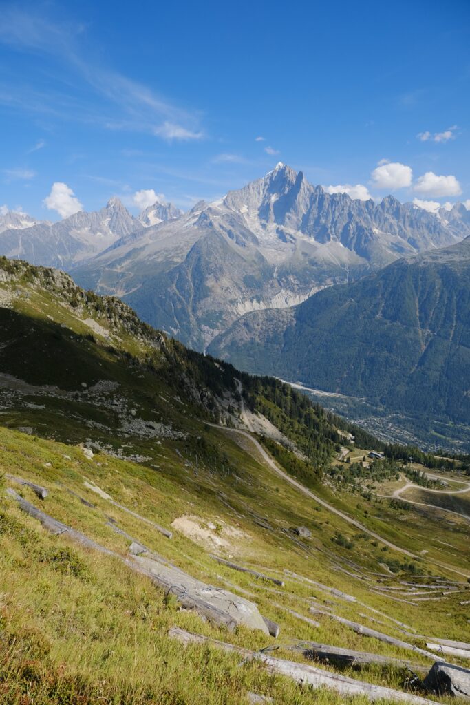 Breathtaking mountain landscape with rugged peaks rocky slopes green hillside and clear blue sky Wallpaper