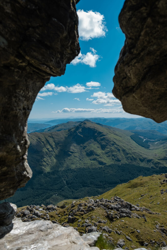 Breathtaking mountain landscape with rugged rocks lush greenery and vivid blue sky wallpaper