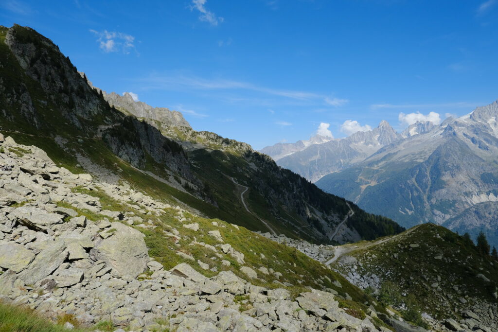 High-resolution mountain landscape wallpaper with rugged rocks green slopes and clear blue sky