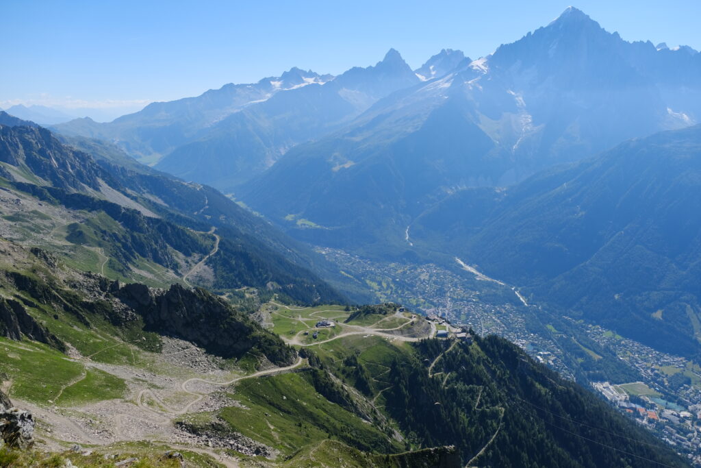 Breathtaking mountain landscape with rugged slopes green valleys winding trails under blue skies wallpaper