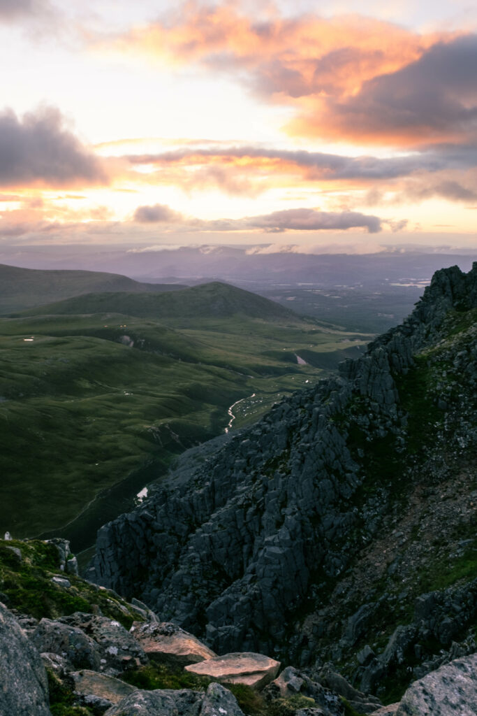 Breathtaking landscape with rugged rocks steep hills winding stream and warm sunset sky wallpaper