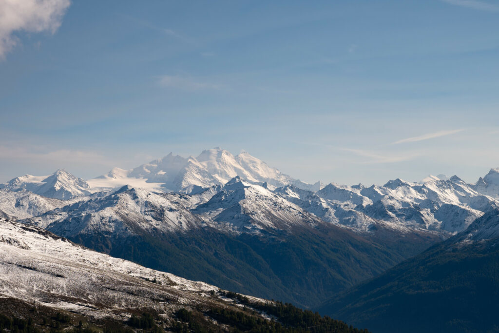 Breathtaking mountain range with rocky peaks snow dusting clear blue sky wallpaper background