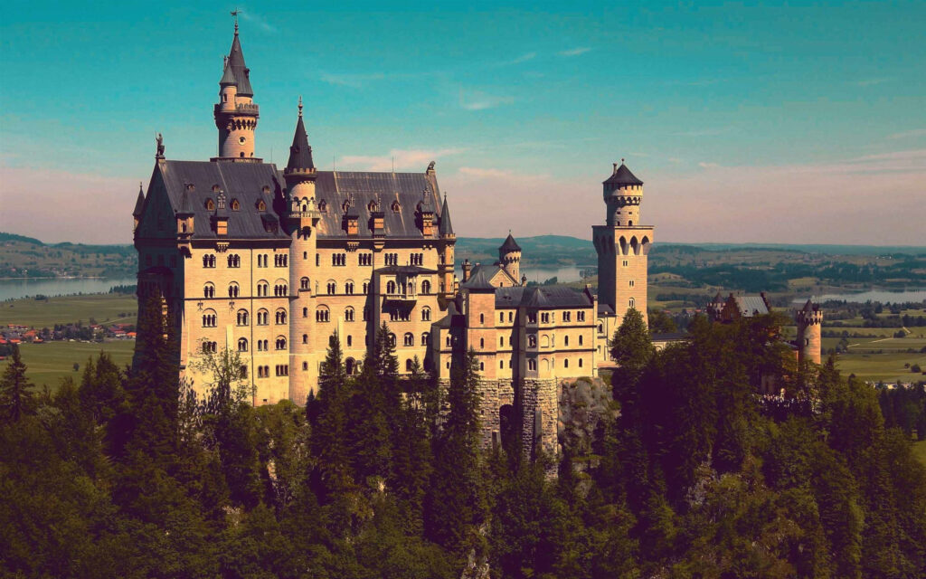 Neuschwanstein Castle in Sunlit Serenity - Stunning Wallpaper Background