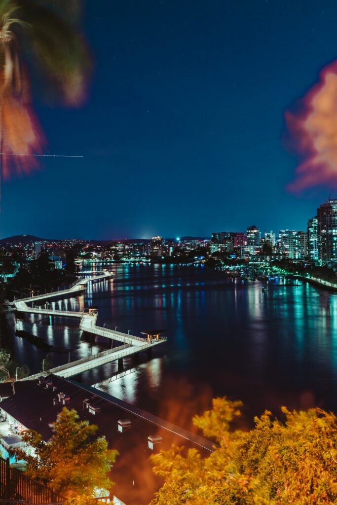 Aerial Night View: Vibrant City Lights & Reflective River Wallpaper