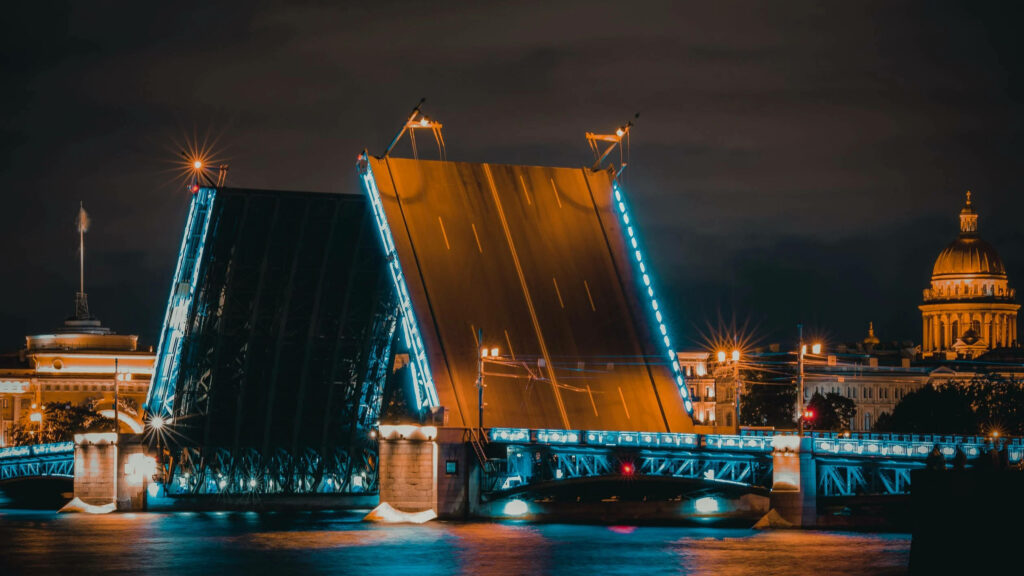 Breathtaking Night View: Drawbridge Opening in Luminous Cityscape Wallpaper