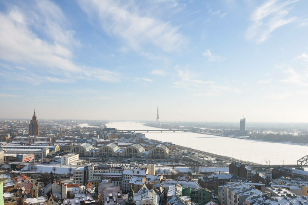 Breathtaking Riga Skyline: Snowy Rooftops & Serene Horizon Wallpaper