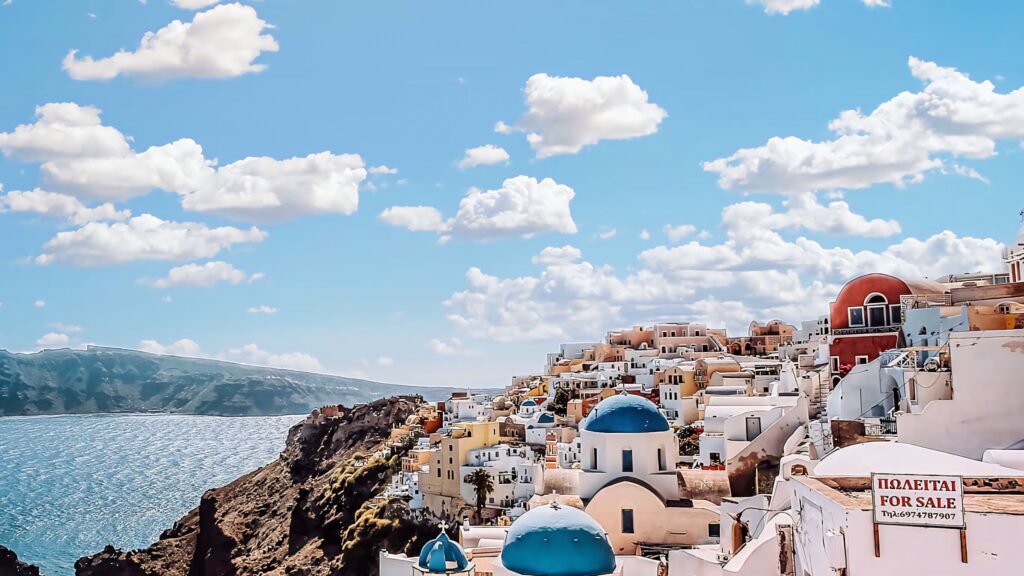 Breathtaking Santorini Cliffside View with Whitewashed Buildings Wallpaper