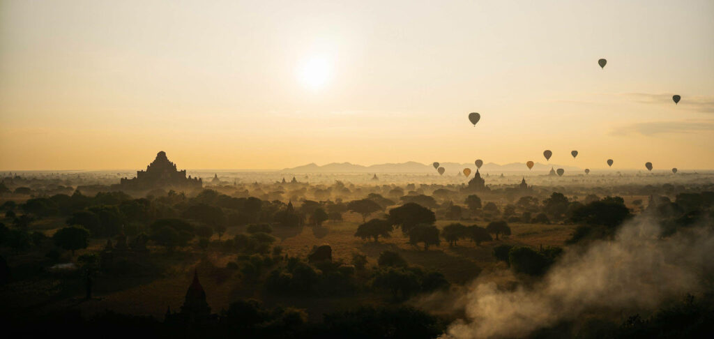 Breathtaking Burmese Skyline Harmonized with Serene Hot Air Balloons Wallpaper