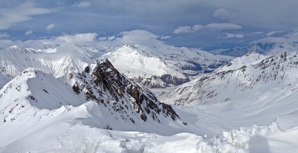 Snow-covered towering alpine mountains with sharp peaks under a clear blue winter sky wallpaper