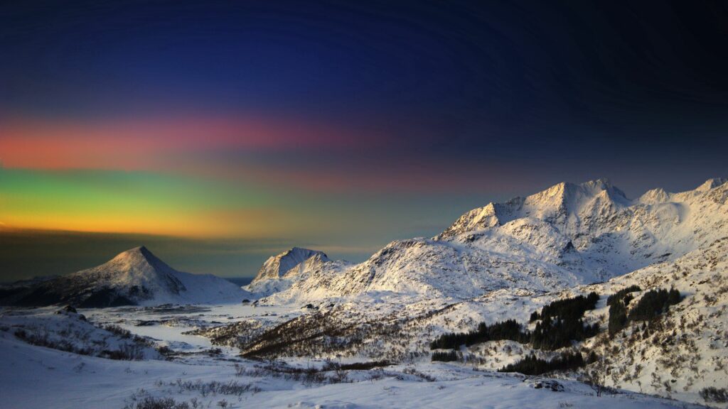 Snow-covered mountain peaks under twilight sky with vibrant colors and soft gradients wallpaper