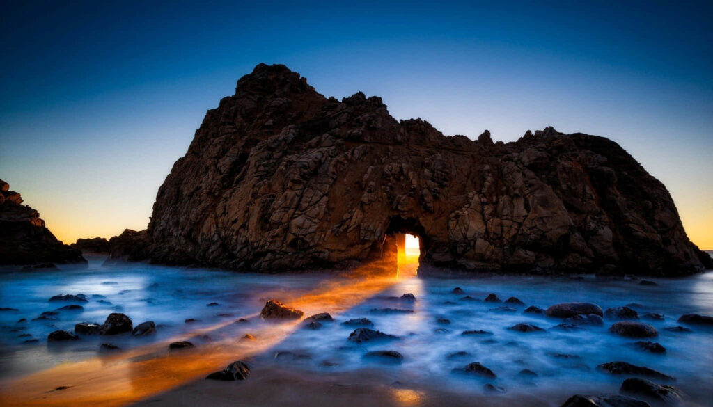 Rugged Beach Sunset Wallpaper: Natural Rock Archway & Golden Glow